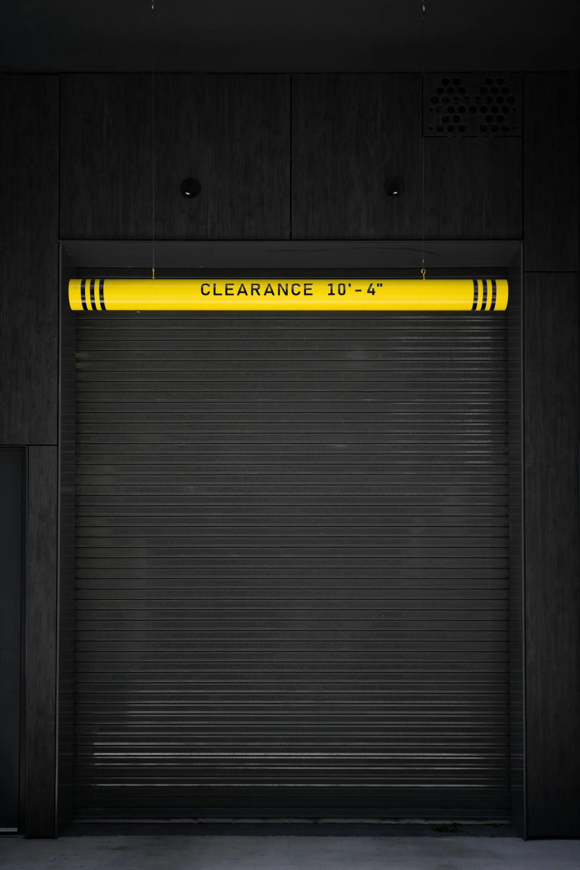 Commercial roll-up door under a yellow clearance bar